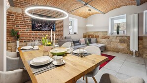 A dining area with a brick ceiling, a wooden table set for a meal, and a cozy seating arrangement. - Apartmentferienhaus Schlag (Naumburg)
