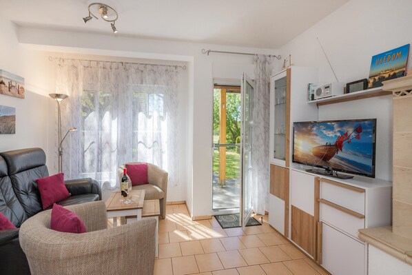 A living room with a sofa, a coffee table, and a television.