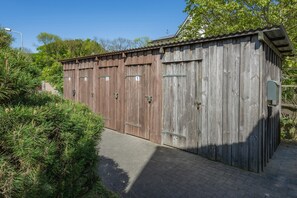 A wooden shed with numbered doors, a metal door handle, and a small window. - Moderne Ferienwohnung mit Gartenblick in Koserow (Koserow)