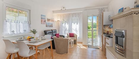 Un espacio habitable amplio y luminoso, con comedor, asientos y chimenea.