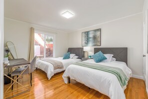 A room with two beds, a desk, and a chair.