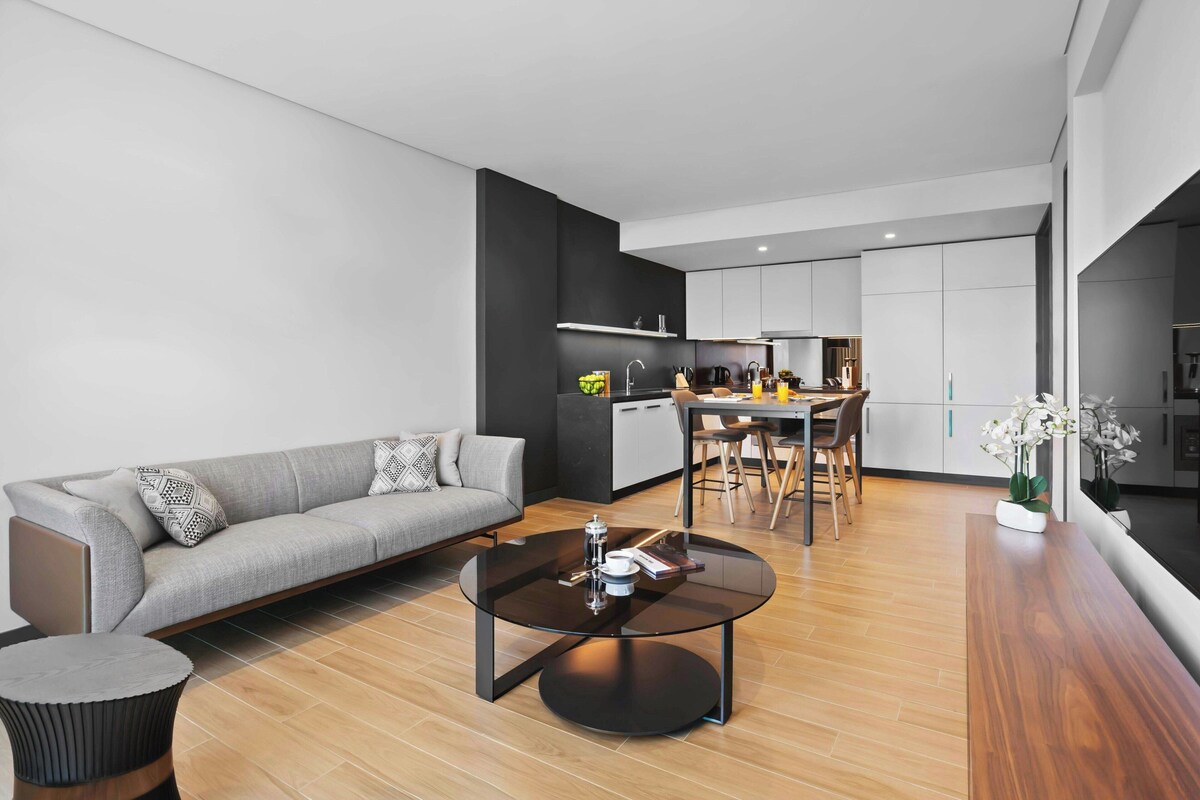A modern living room with a sofa, coffee table, and dining area.