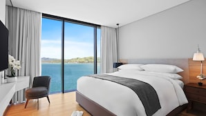 A modern hotel room with a large bed, a desk, and a chair. - Marriott Executive Apartments Port Moresby (Port Moresby)