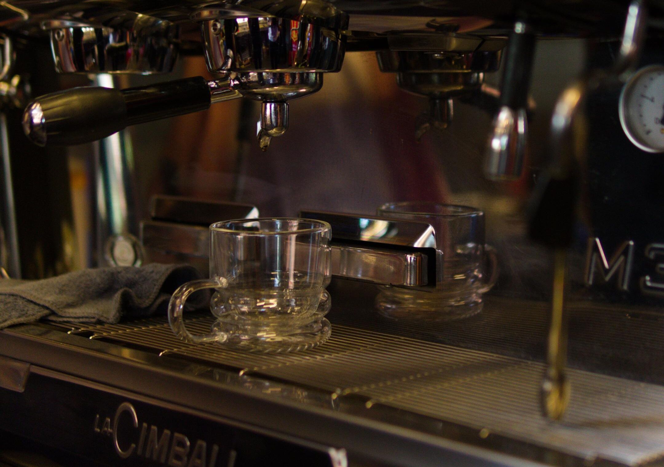 A La Cimbali espresso machine with a glass cup placed on the drip tray.
