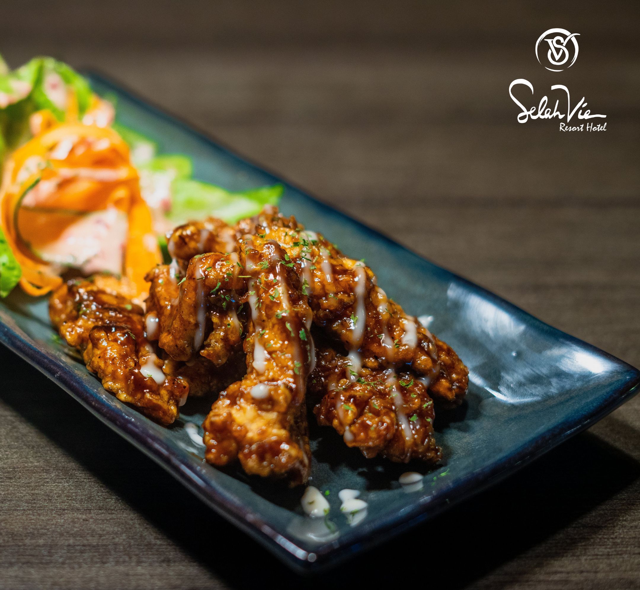 A plate of chicken tenders with a side salad and a decorative orange slice.