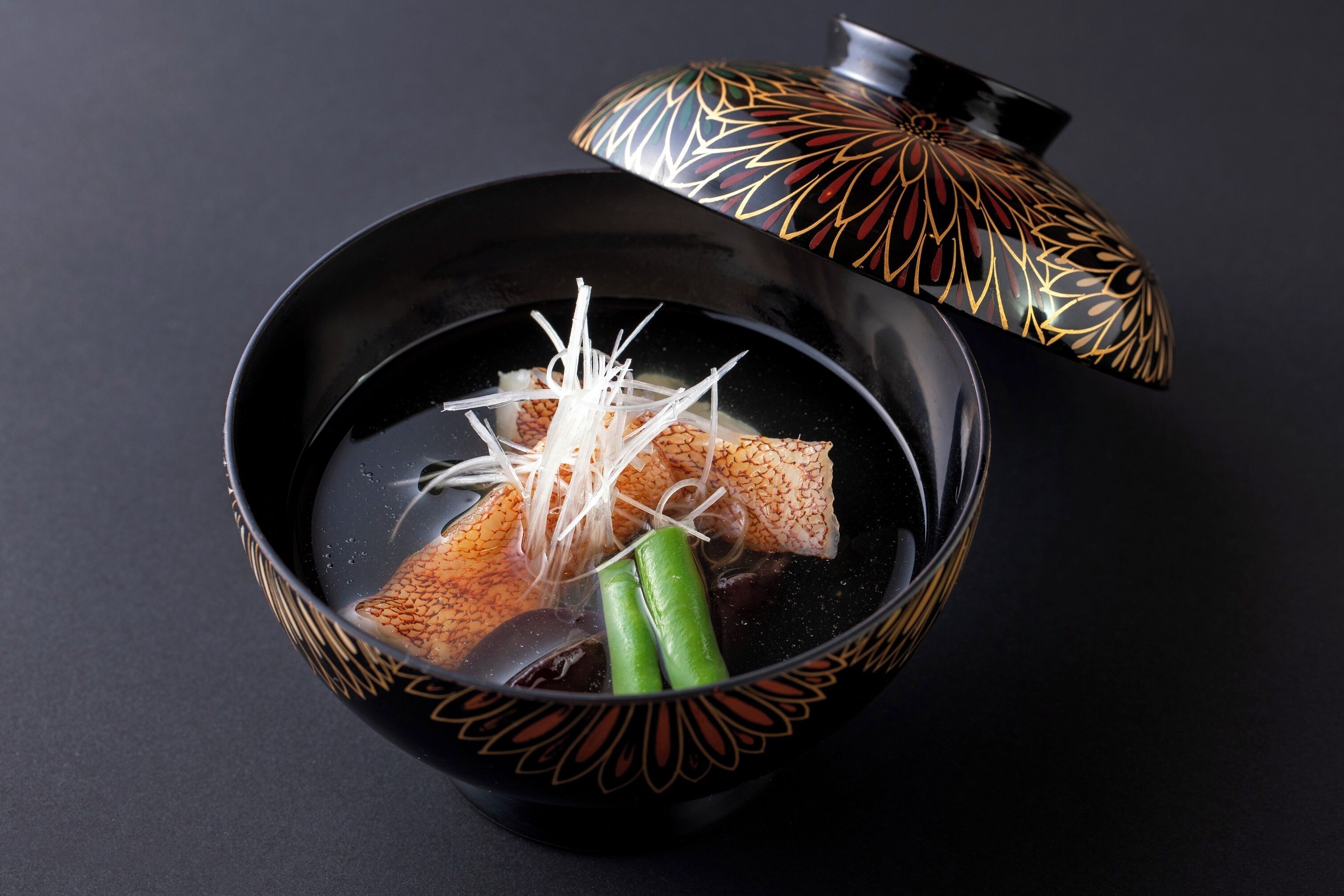 A bowl of soup with a decorative lid.