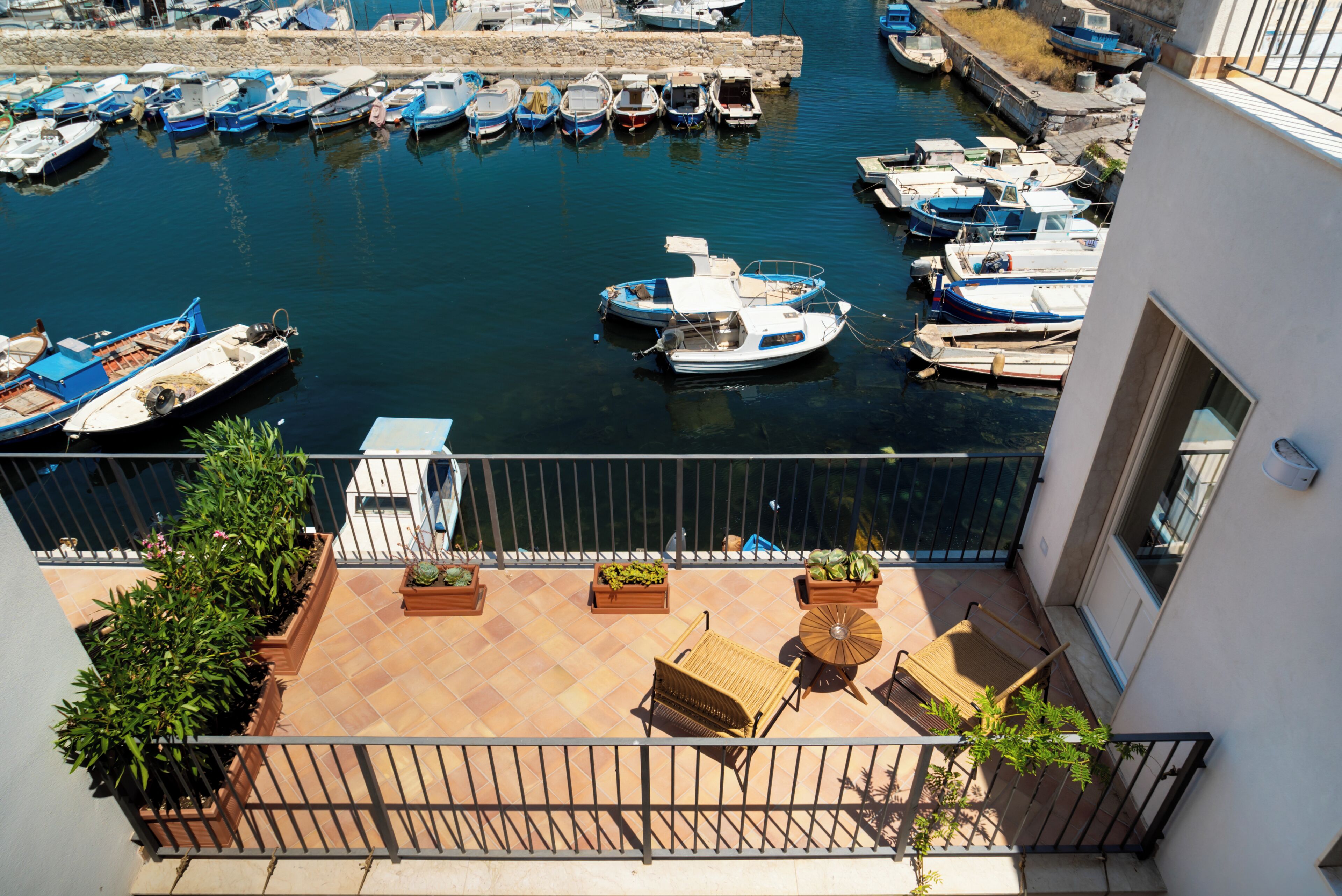 Un balcon donnant sur une marina où sont amarrés des bateaux.