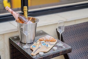 A table with a bottle of champagne, two glasses, a croissant, and cheese on a tray. - Mokpo H Avenue Hotel Peace Plaza (Mokpo)