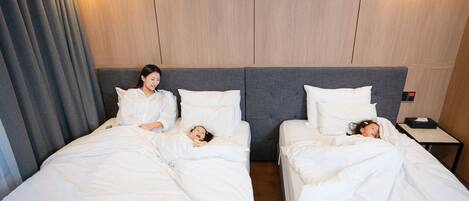 A hotel room with two beds, a nightstand, and a wall-mounted control panel.