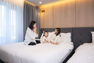Una habitación de hotel con una cama grande, una mesita de noche y una ventana con cortinas.