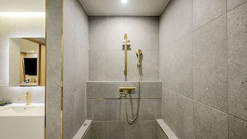 A modern bathroom with a shower, a sink, and a mirror.