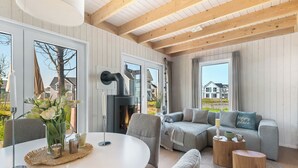 Un salon moderne avec une cheminée, une table à manger ronde et un coin salon confortable.