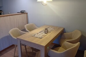 Un comedor con mesa de madera y cuatro sillas.