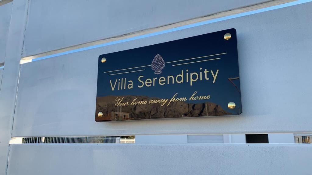 A sign for Villa Serendipity with the text "Your home away from home" and a logo.