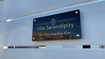 A sign for Villa Serendipity with the text "Your home away from home" and a logo.