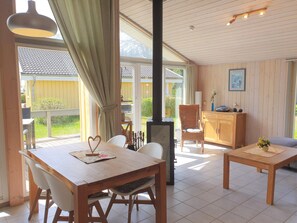 Ein geräumiger Raum mit einem Holztisch, Stühlen, einer Couch und einem Kamin.