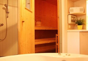 Bathroom features a bathtub, shower with handheld showerhead, and a radio.
