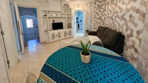 A modern living room with a TV, sofa, and dining area. - Port Cambrils 11004 (Cambrils)