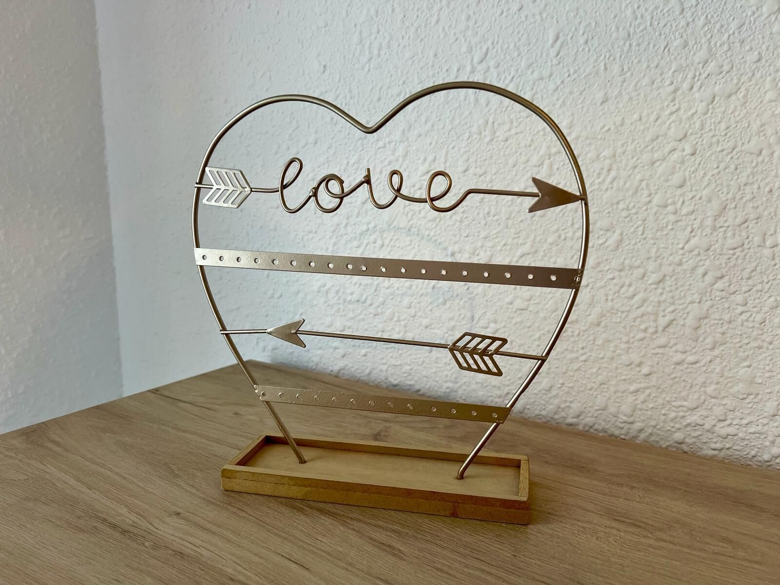 A heart-shaped metal sign with the word "love" and arrows pointing in opposite directions.