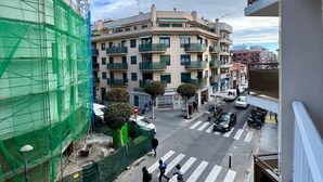 A multi-story building with balconies, a pedestrian crossing, and a street with cars and pedestrians. - Port Cambrils 11004 (Cambrils)