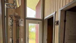 A hallway with wooden walls, a tiled floor, and a door leading to a garage.