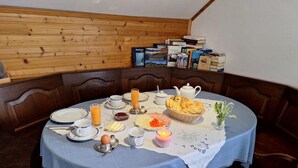 Ein Esstisch mit Frühstücksgebäck, umgeben von Holzwandverkleidung und Büchern in einem Regal.