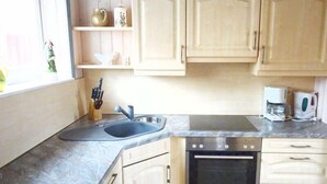 Una cocina con pileta, estufa y alacenas.