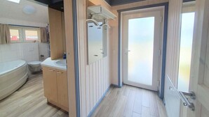 Ein Badezimmer mit Badewanne, Toilette und Waschtisch.