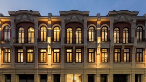 Un edificio de varios pisos con ventanas arqueadas y balcones, que presenta un estilo arquitectónico clásico.