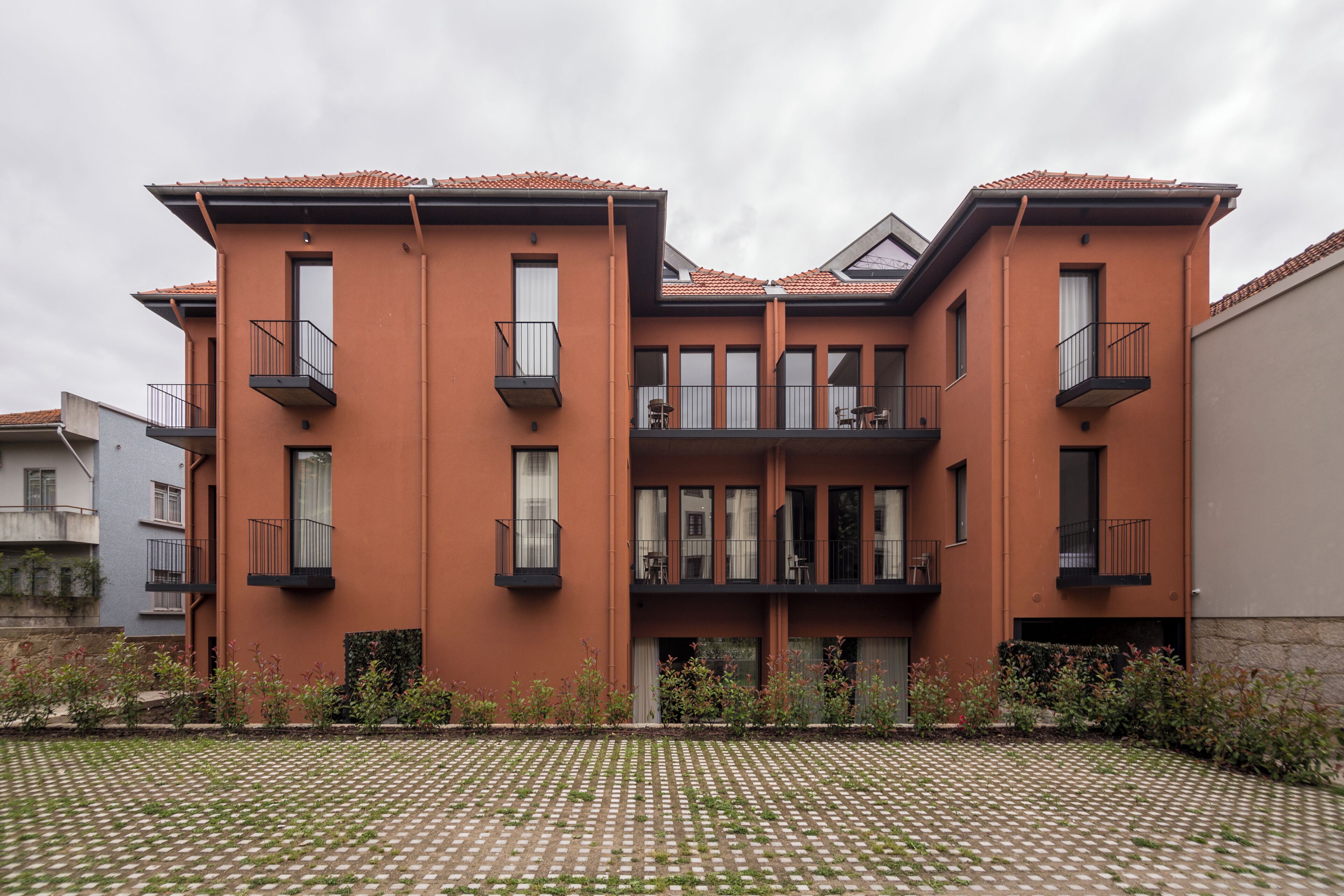 A multi-story building with balconies and large windows.