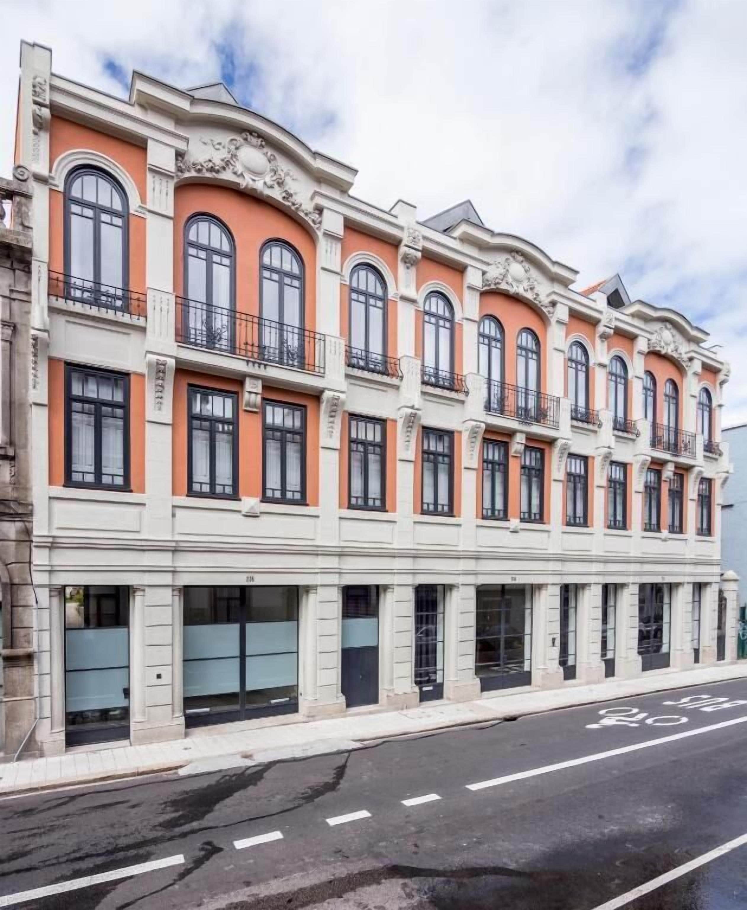 A multi-story building with a classic architectural style, featuring arched windows and decorative moldings.