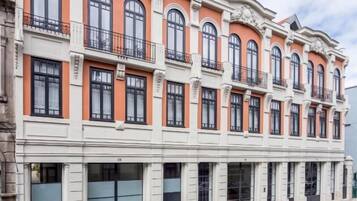 A multi-story building with a classic architectural style, featuring arched windows and decorative moldings.