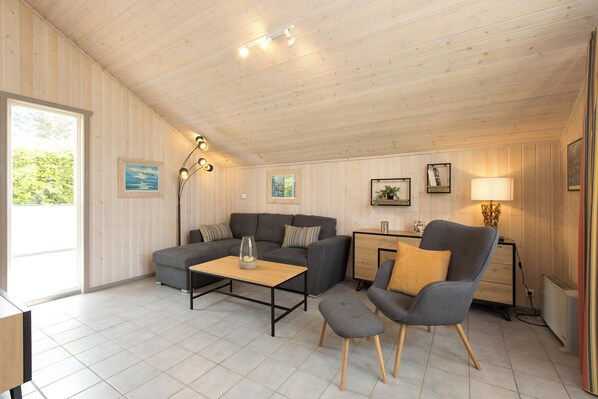 Una habitación acogedora con sofá, sillón, mesa de centro y escritorio con lámpara.