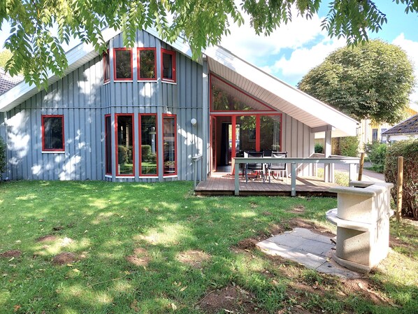 Una casa moderna con terraza y zona exterior cubierta.