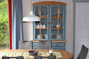 Una mesa de comedor con mantel estampado, una vela y una cesta.