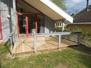 Un pontile in legno con una porta vetrata che dà su un portico coperto.