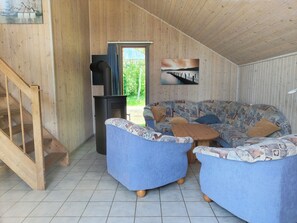 Un interior de madera con un sofá, una mesa de centro y una chimenea.