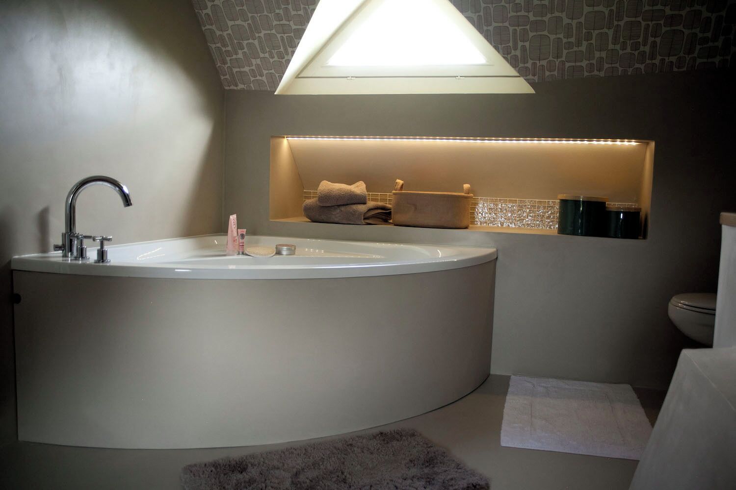 Une salle de bain moderne avec une baignoire sur pieds, des toilettes et un espace douche.