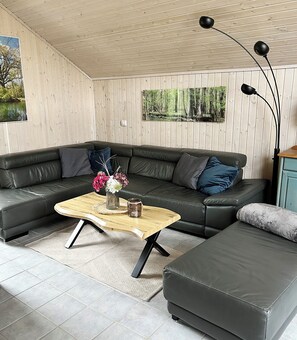 A modern living room with a sectional sofa, a wooden coffee table, and a floor lamp.