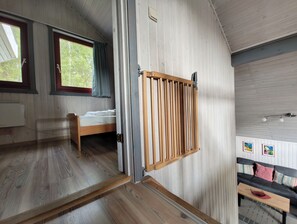 A room with a bed, a wooden slat wall, and a sofa.