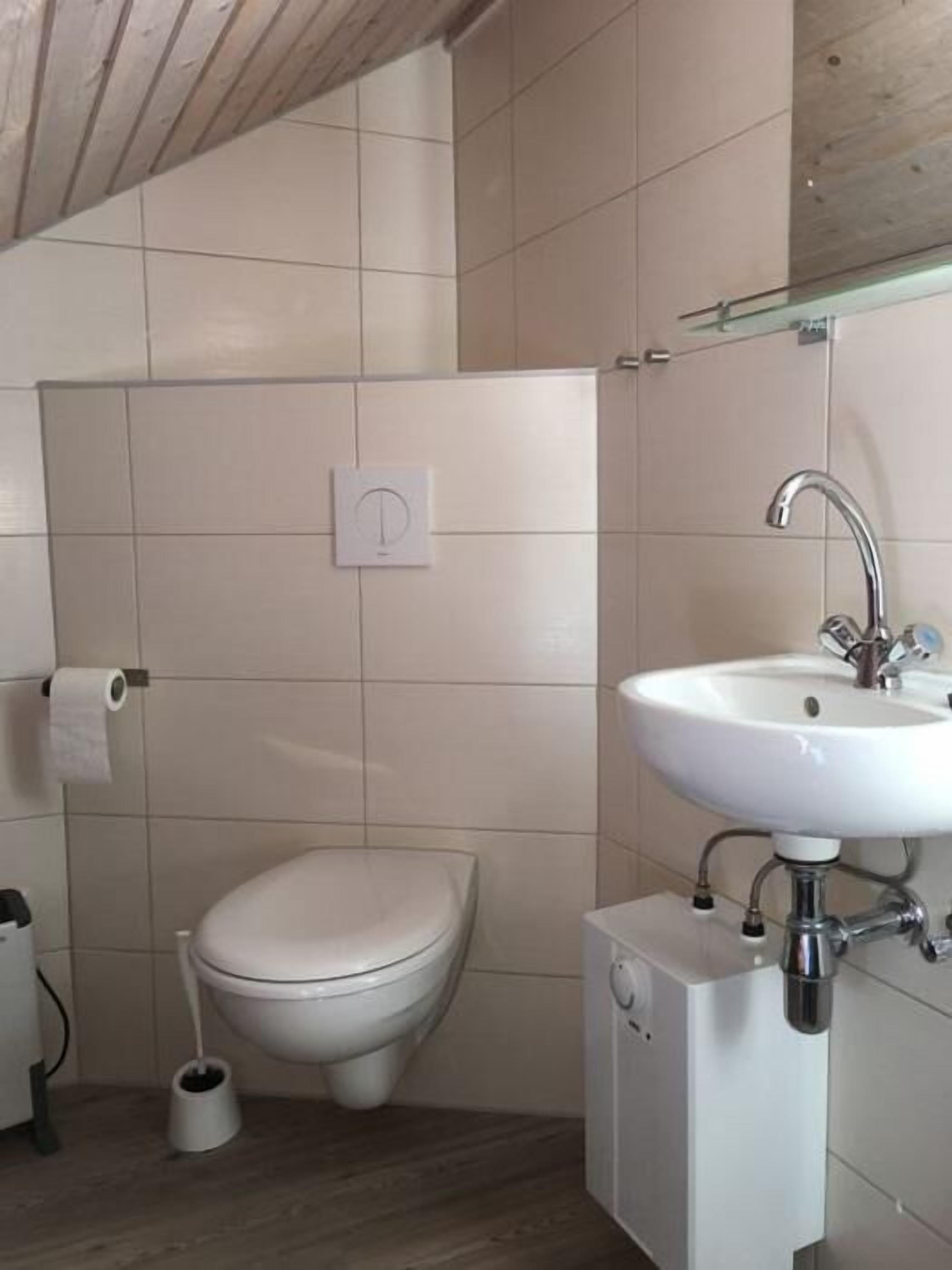Et badeværelse med toilet, bidet og vask.