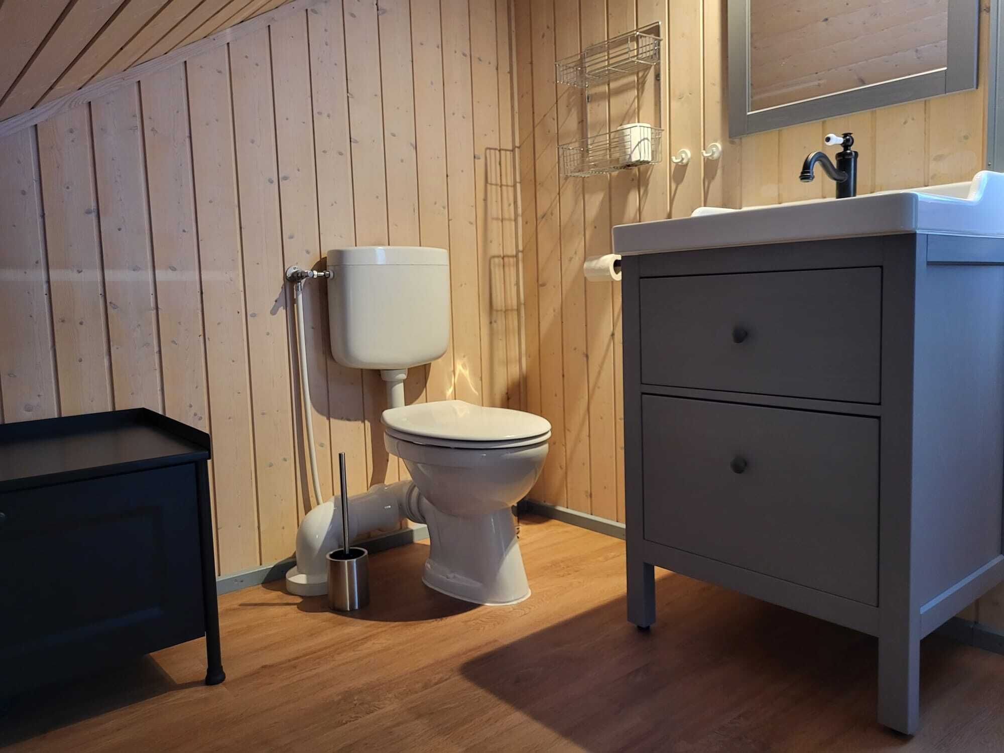 Une petite salle de bain comprenant des toilettes, un lavabo et un meuble de rangement.