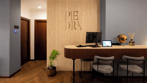 Zona de recepción con una pared de madera que muestra el texto 