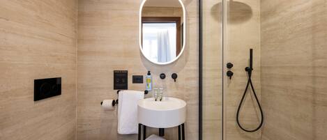 A modern bathroom with a toilet, sink, and shower.