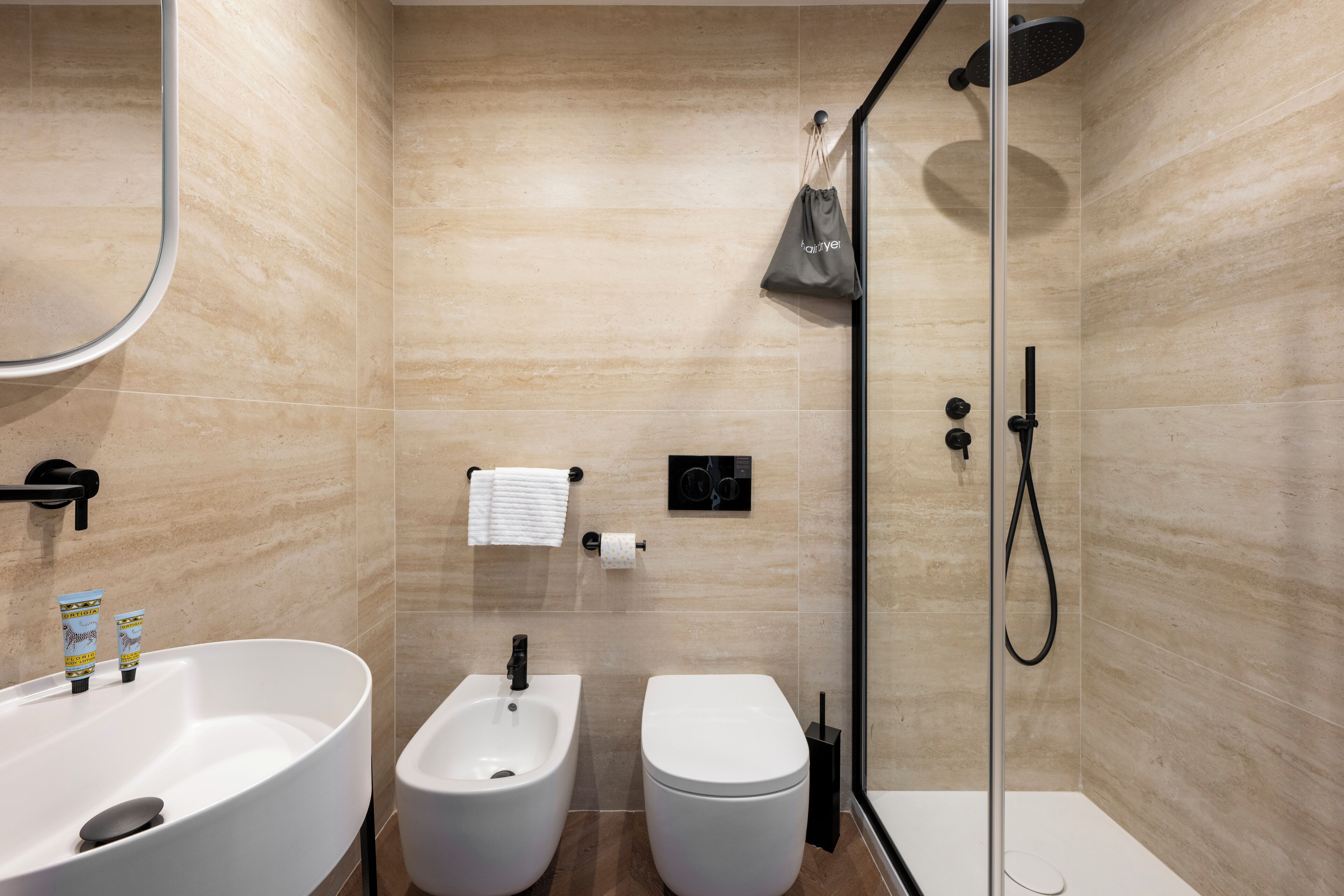 Une salle de bain moderne avec une baignoire sur pieds, un bidet et un espace douche.