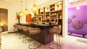 Una cocina moderna con una isla central, taburetes de bar e iluminación colgante.