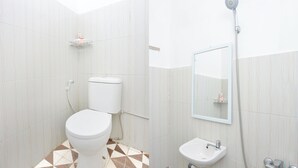 A bathroom with a toilet, bidet, sink, and a shower. - OYO 634 Elga Sastro Inn Syariah (Yogyakarta)
