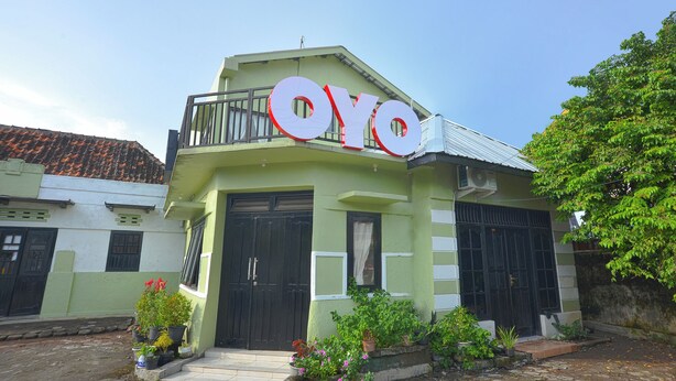 A building with a sign reading "OYO" and a balcony with railings. - OYO 634 Elga Sastro Inn Syariah (Yogyakarta)