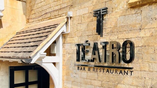 Un bâtiment à la façade en pierre, sur lequel on peut lire l’inscription « TEATRO BAR & RESTAURANT ».