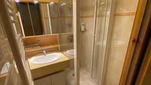 A bathroom with two sinks, a glass shower enclosure, and a mirror. - Charming duplex with balcony, near ski and shuttle, parking, WIFI (Châtel)